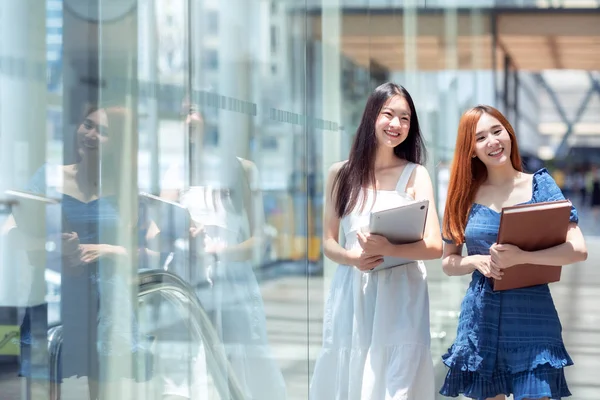 Два азиатских студента идут в библиотеку в ее университете — стоковое фото