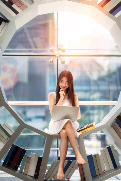 Asiatisk tjej elev Läs en lärobok i biblioteket på hennes universitet — Stockfoto