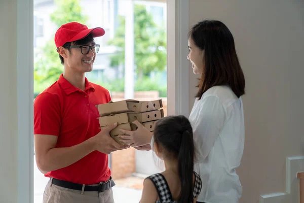 Asiatique femme Recevoir pizza boîte de pizza garçon à la maison — Photo