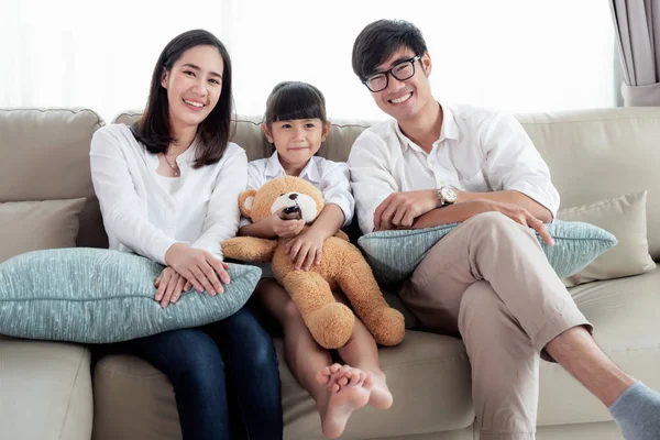 Asiática familia viendo televisión y sentarse en sofá en leving habitación —  Fotos de Stock