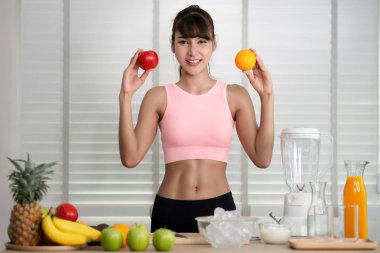 Asyalı kız bir sürü meyveden içecek yapar.