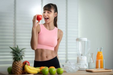 Asyalı kız bir sürü meyveden içecek yapar.