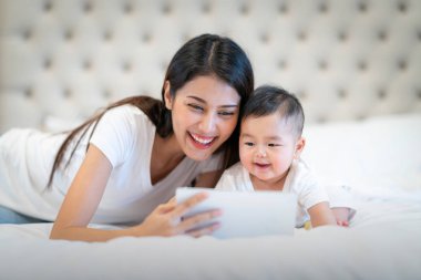 Asyalı anne uyumadan önce bebeğiyle bir video klipte görünüyor.