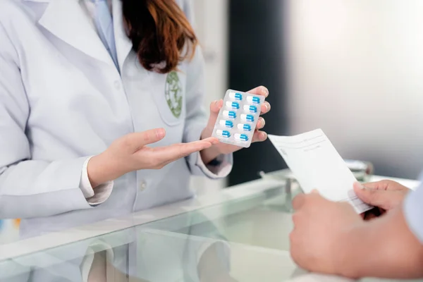 Specialist explain about how to use a drug capsule in her drugst — Stock Photo, Image