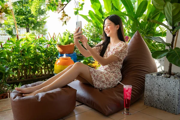Hezké Asijské Dívka Relaxační Rozkládací Pohovce Procházení Internetu Smartphone Zahradě — Stock fotografie