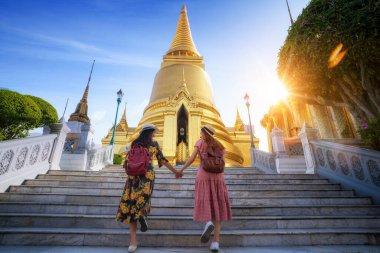 Büyük Saray ve Wat phra kaew Bangkok 'taki bir haritanın yanında seyahat eden iki Asyalı kız arkadaş.