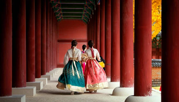 在韩国首尔 身穿汉博克服装的亚洲女孩在秋天的叶园和古宫里散步 — 图库照片
