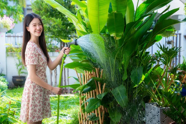 庭に緑の植物を散水美しいアジアの女性の肖像画 自宅の小さな居心地の良い庭 — ストック写真