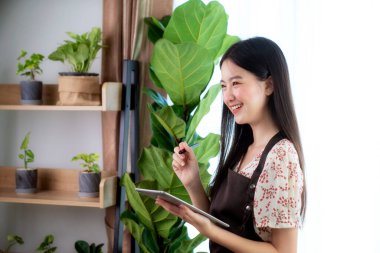 Asyalı kadın bilgisayardan tablet alımı ev ofisindeki müşterisinden çevrimiçi sipariş, bu resim sme, business, plant, job ve başlangıç konsepti için kullanılabilir