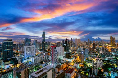 Bangkok şehir manzarası otel binasının çatısından yüksek bina ve günbatımı gökyüzü arka planına sahip.