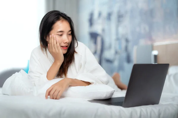 Asyalı Kadın Tatil Arasında Otel Yatağında Bilgisayar Defteri Kullanıyor Resim — Stok fotoğraf