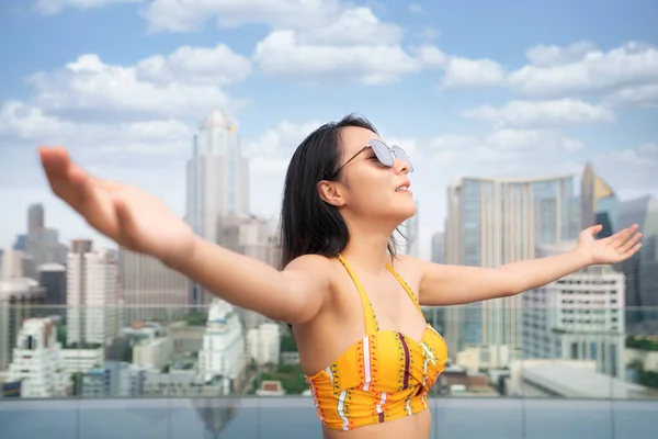 身穿黄色泳衣的亚洲女人在曼谷的屋顶游泳池里放松一下 这张照片可以用来享受自由 运动和放松的感觉 — 图库照片