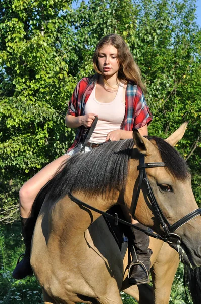 十几岁的女孩在女牛仔风格骑马在夏日阳光明媚的一天 — 图库照片