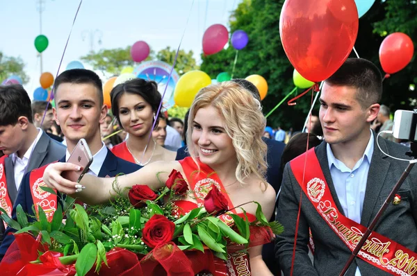 Diplômés de différentes écoles prenant selfie dans un défilé de célébration — Photo