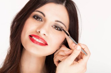 güzel kadın beyaz arka plan üzerinde izole makyaj uygulamak 