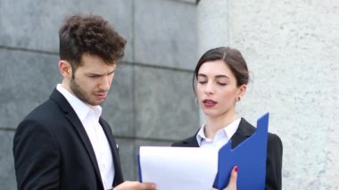 Açık bir belgeyi okurken iş adamları