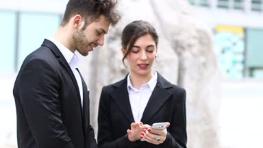 Kendi ofisi önünde bir cep telefonu kullanarak iş adamları