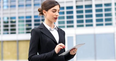 Gülümseyen iş kadını dijital tablet kullanıyor.