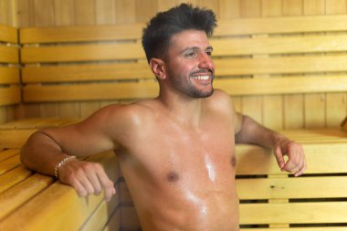 Gülümseyen adam bir buhar odasında sauna banyoda