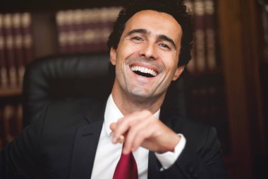 Lawyer smiling in his studio clipart