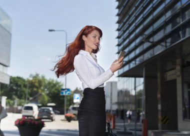 Yürürken cep telefonunu kullanarak iş kadını