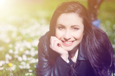 Güzel bir kadın çimenlerde yatıyor.