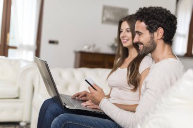 Online alışveriş kavramı, kendi evin oturma odasında bir dizüstü bilgisayar kullanarak çift