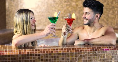 Çift kokteyl içme bir spa, Jakuzi banyo yapıyor 