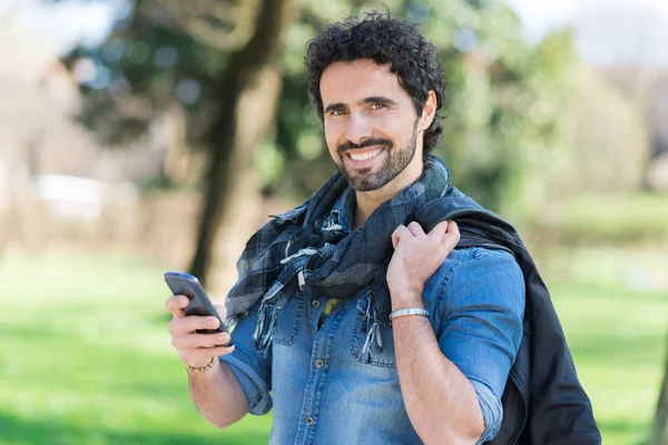 公園で彼の携帯電話を使用している人の肖像画 — ストック写真