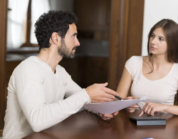 Couple having a conversation while doing accounting at home
