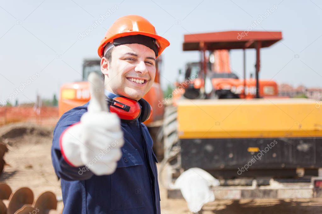 Portrait of worker in a construction site showing thumb up 
