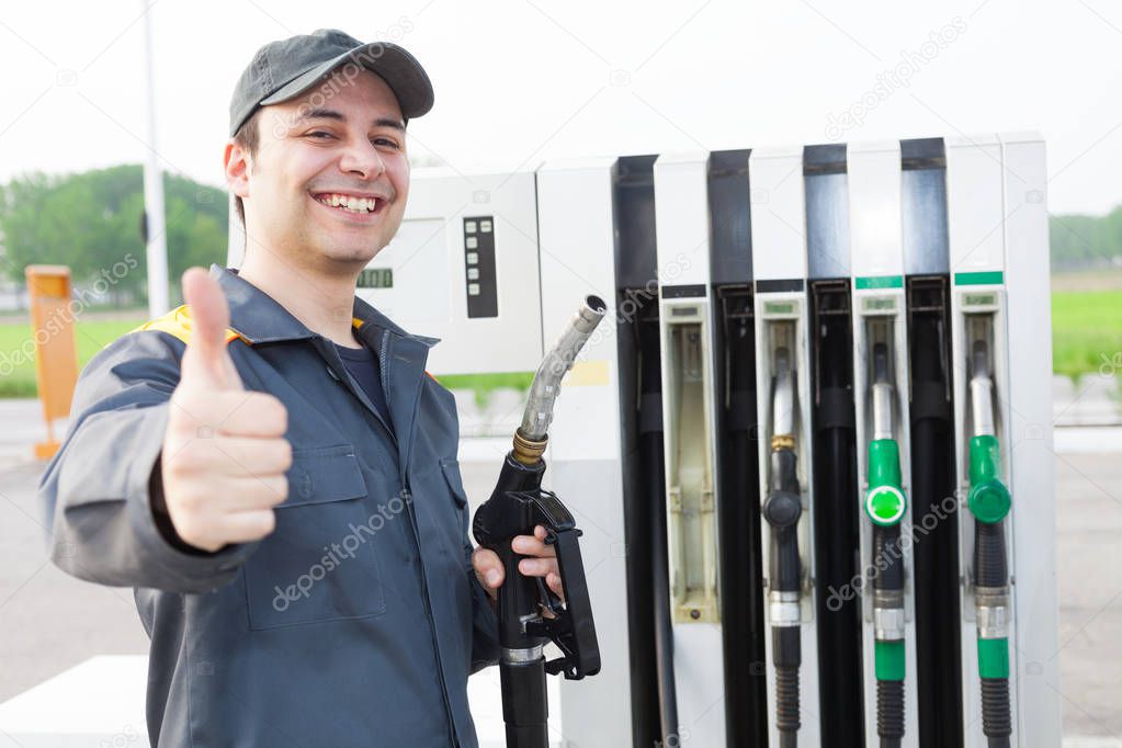 Smiling worker at the gas station giving thumbs up