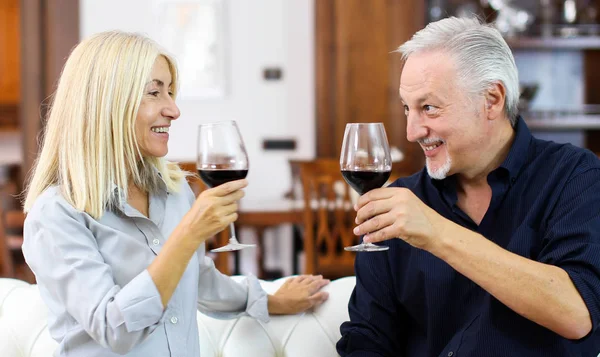 Mature couple toasting wine glasses to celebrate a special occasion