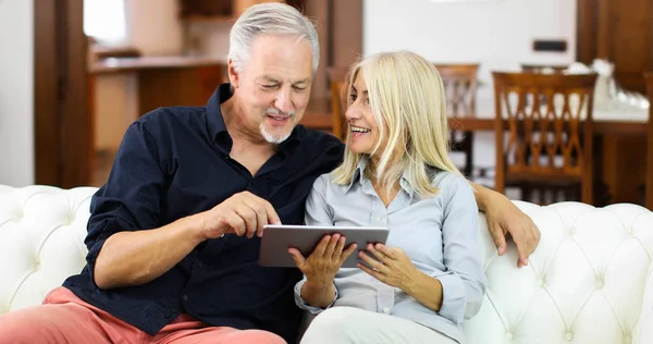 Portrait Smiling Mature Couple Using Digital Tablet Sofa Home — Stock Photo, Image