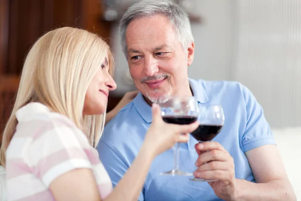 Mature couple toasting wine glasses to celebrate a special occasion