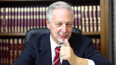 Üst düzey iş adamı ok gösterilen gülümseyen portresi oturum onun kütüphane 4k