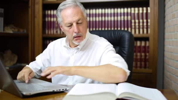 Man Using His Laptop Reading Book — Stock Video