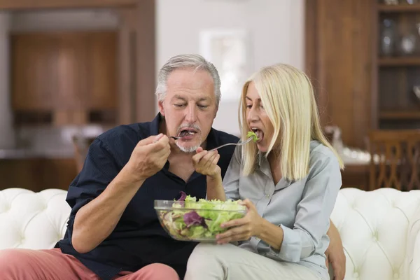 成熟夫妇在家里吃健康的沙拉 — 图库照片