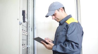 Bir elektrikçi tablet kullanarak iş yerinde portresi 