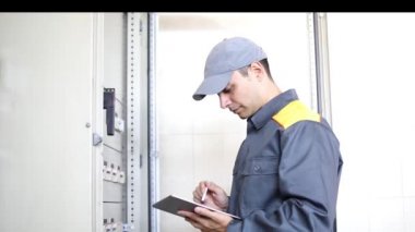 Bir elektrikçi tablet kullanarak iş yerinde portresi 