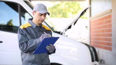 Mekanik bir kamyon motoru kontrol ettikten sonra belgeleri yazdırma