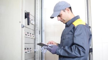 Bir elektrikçi tablet kullanarak iş yerinde portresi 