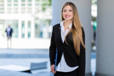 Modern bir şehir ortamında kendine güvenen genç bir bayan yönetici.