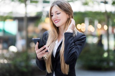 Web içeriğine gözatmak için onun smartphone kullanarak ve açık göndermesini genç iş kadını