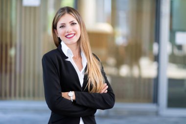Kendine güvenen genç kadın Yöneticisi çapraz kollu modern bir kentsel ortamda açık