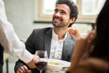 Garson bir çifte yemek servisi yapıyor.
