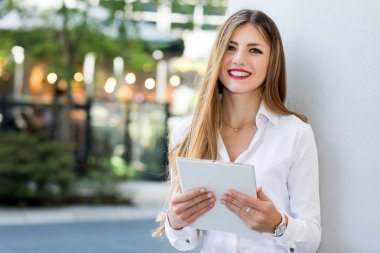 Gülümseyen iş kadını dijital tablet kullanıyor.