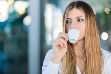 Kafede kahve içen güzel bir kadın.