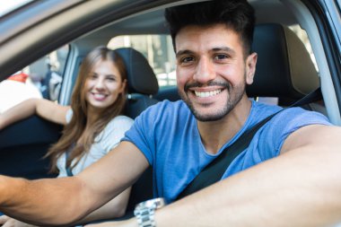 Happy couple driving in a car clipart