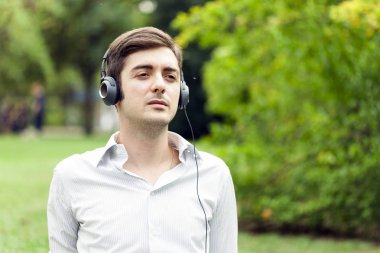 genç adam bir parkta müzik dinleme